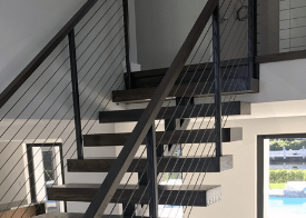 Black aluminum railing on modern floating stairs in South Florida
