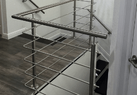 Stainless steel bar railing installed around an interior stair opening