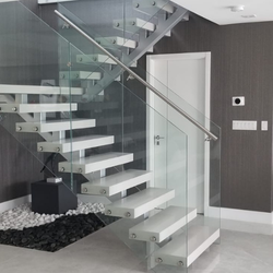 Floating white staircase with frameless glass railing in a luxury South Florida home